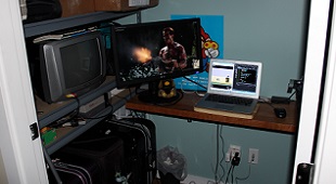 Matthew Langille's home office set-up at Sprixelsoft. Pay attention to the NES hooked up to a small CRT television as well as the super mario poster on his wall